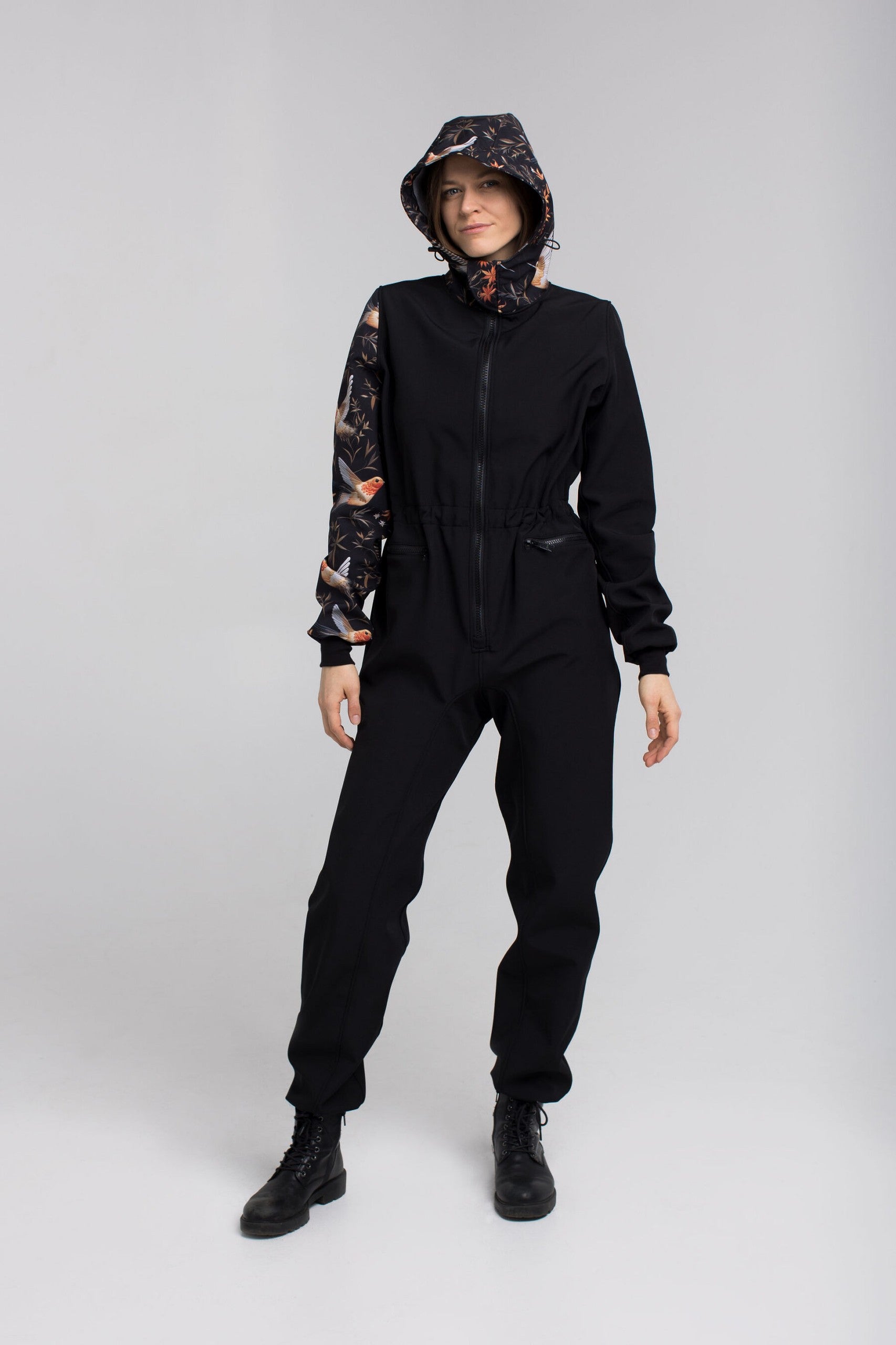 NUCKÖ EMMA kombinezona kapuce ar regulējamu dizainu un spiedpogām.